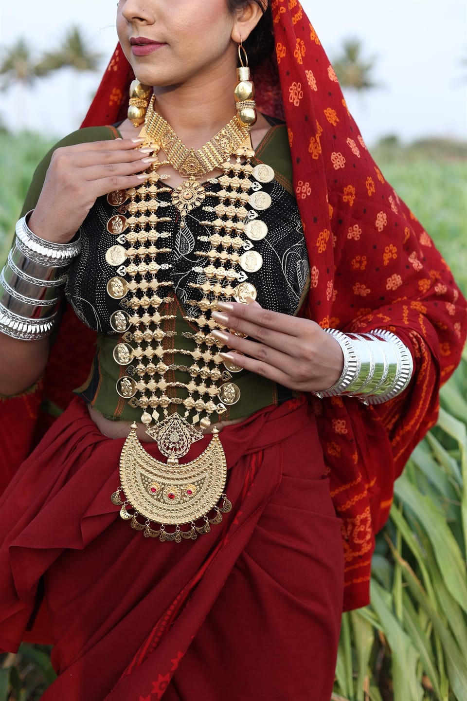 Layered gold coin chandan haar and silver bangles worn in the fields near Porbandar