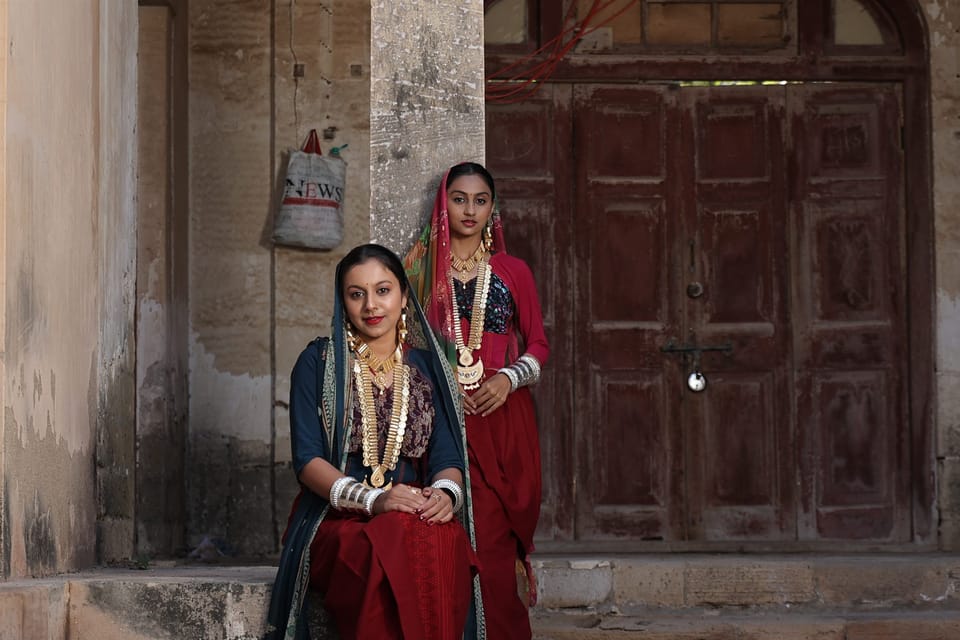 Brides from Porbandar's Maher community in layered gold necklaces and silver bangles